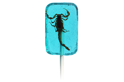 A blue lollipop with a scorpion embedded inside it, attached to a white stick.